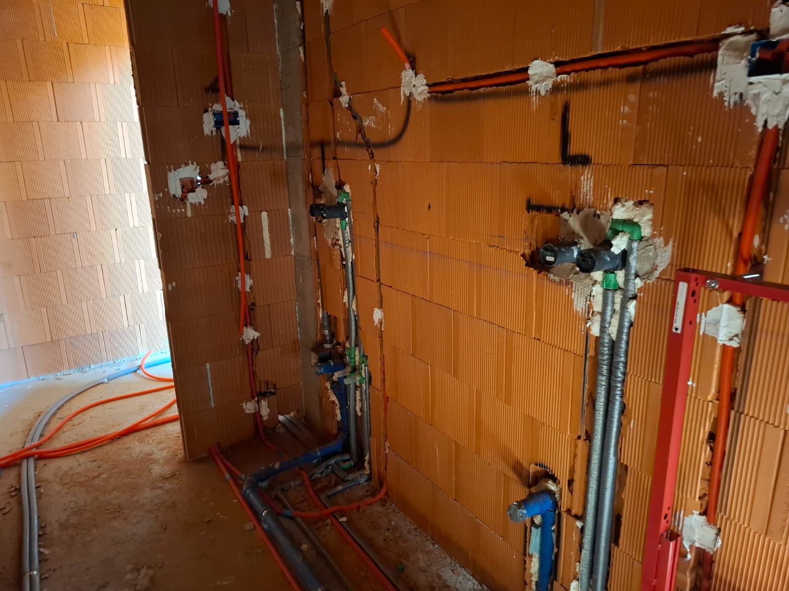 Razvod vodovodnih i kanalizacijskih instalacija na zidu u fazi grubih radova